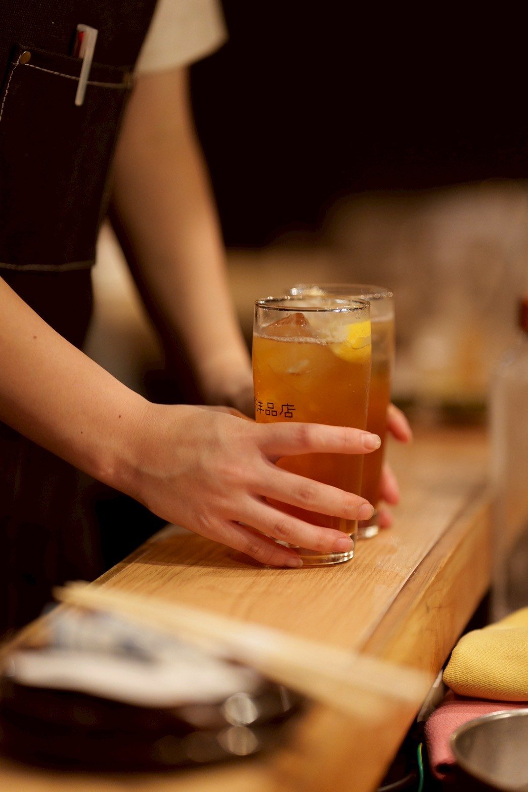 カウンターでグラスの飲み物を差し出す手元